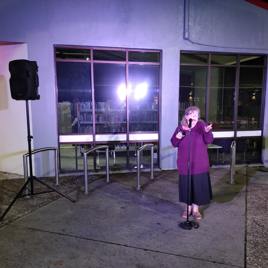 A comedian performs outside the outside Pt Chev Library