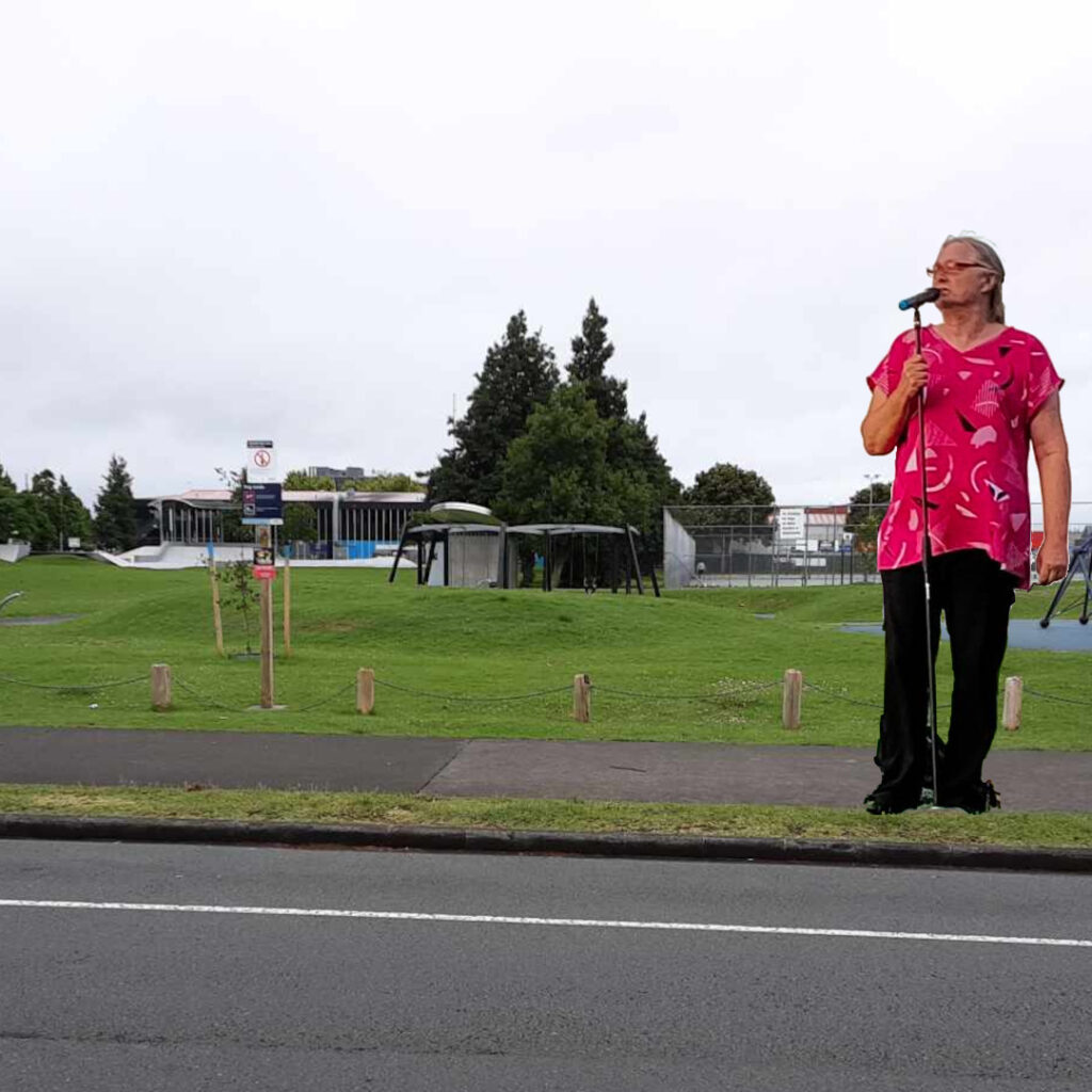 A comedian outside a grassy park