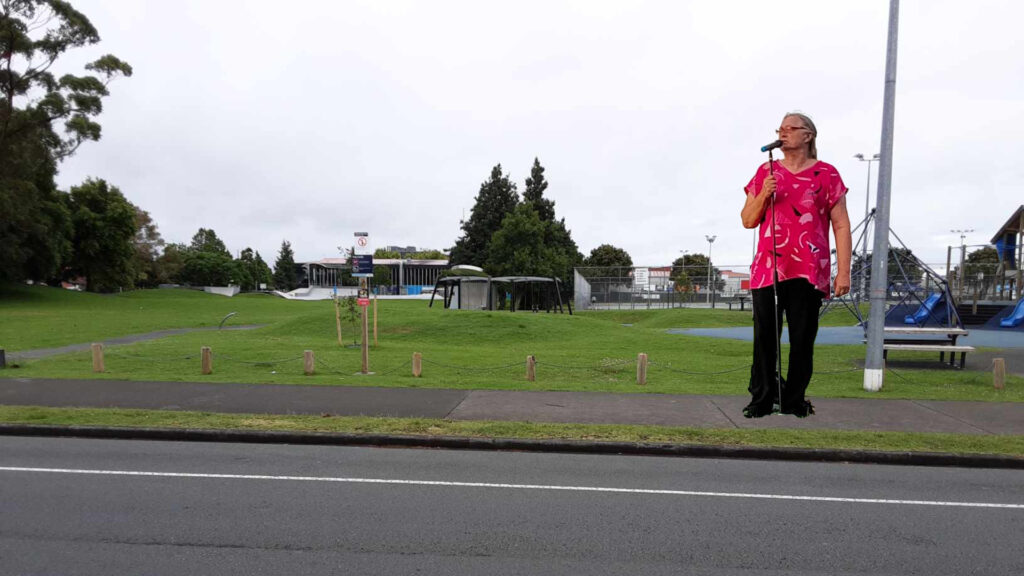 A comedian outside a grassy park