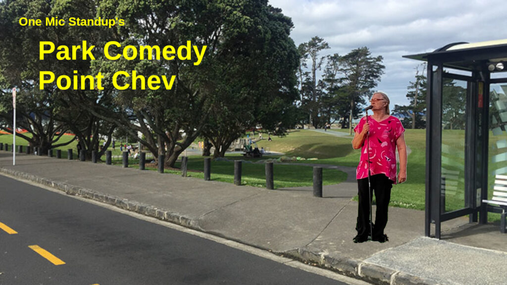 A comedian stands in front of a bus stop outside a park